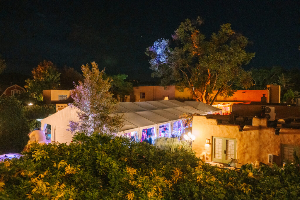 The evening view of a glowing reception tent at La Posada in Santa Fe—an ideal backdrop for a full wedding weekend experience.
