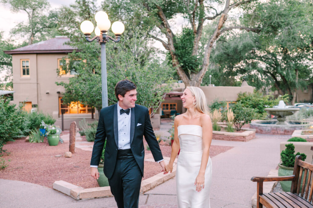 Wedding couple walks through the lush garden pathways at La Posada in Santa Fe—ideal for portraits and private moments.