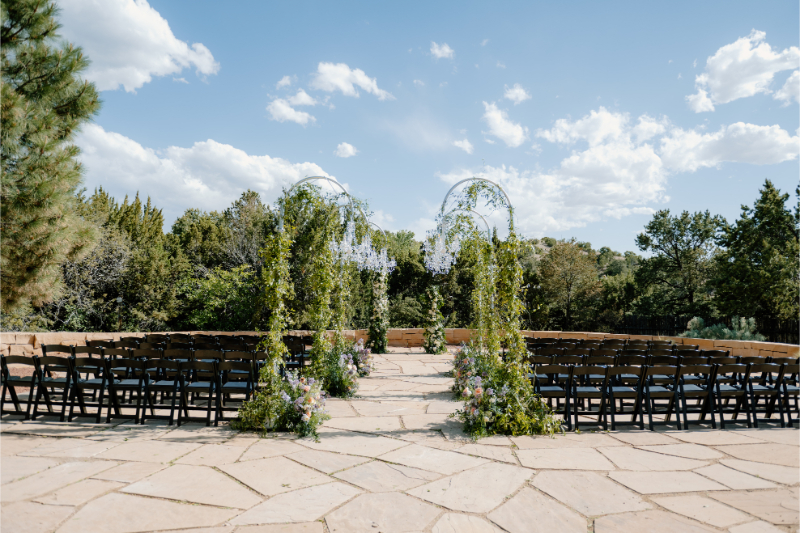 Aisle surrounded by lush greenery and chandelier wedding ceremony aisle decor.