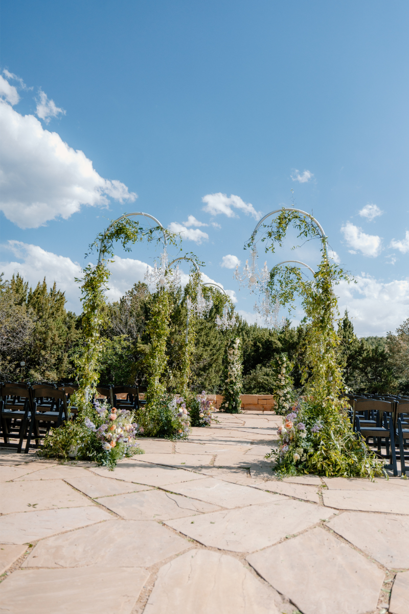 Aisle surrounded by lush greenery and chandelier wedding ceremony aisle decor.