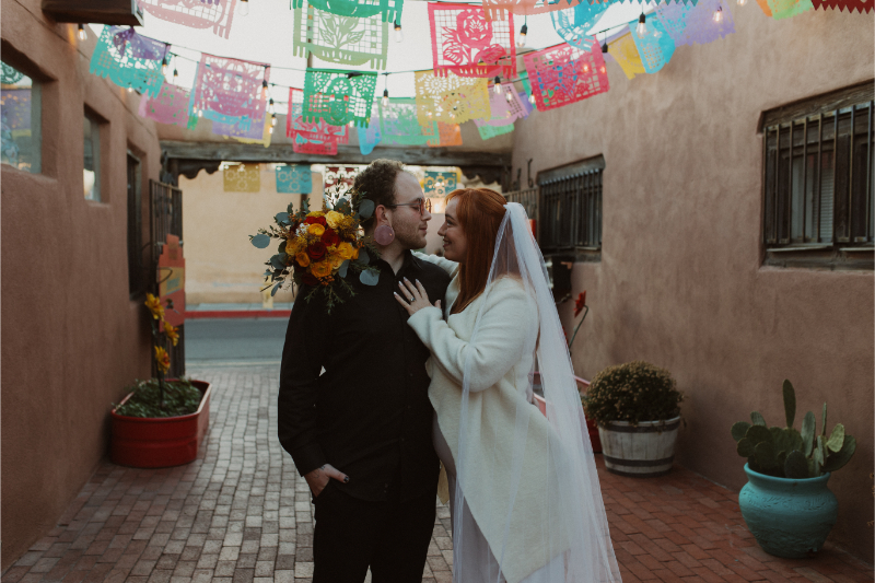 Newlyweds plan a fall wedding in New Mexico, posing in Old Town Square.