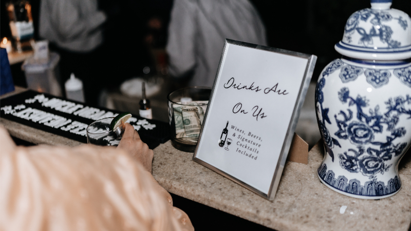 Sign sitting at bar during wedding rehearsal dinner.