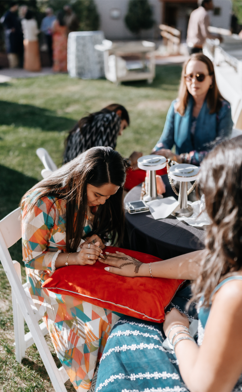 Henna tattoo artist set up for wedding rehearsal dinner.