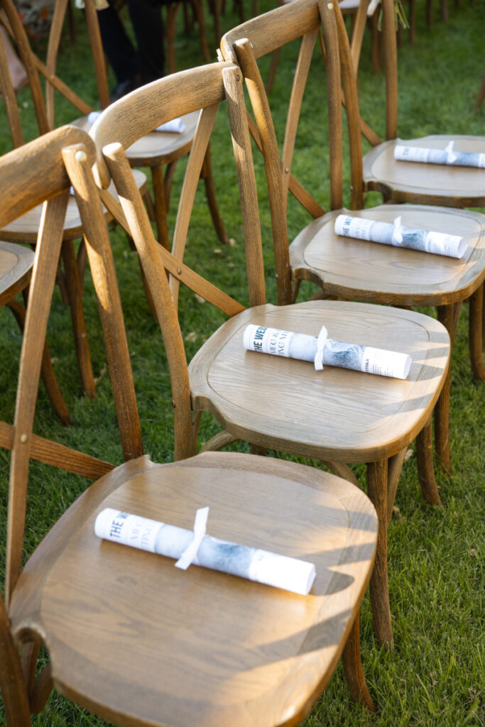 Wedding weekend itinerary sits on guest seats during welcome event.