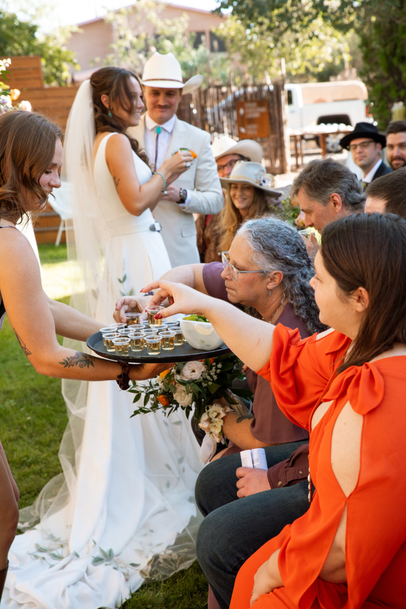 Bartender passes out tequila shots during wedding unity ceremony.
