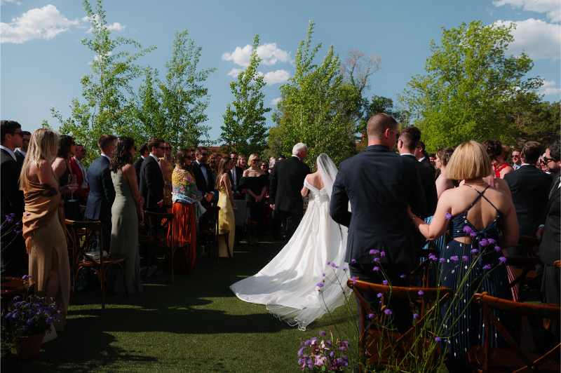 View of back of ceremony as bride walks down the aisle.