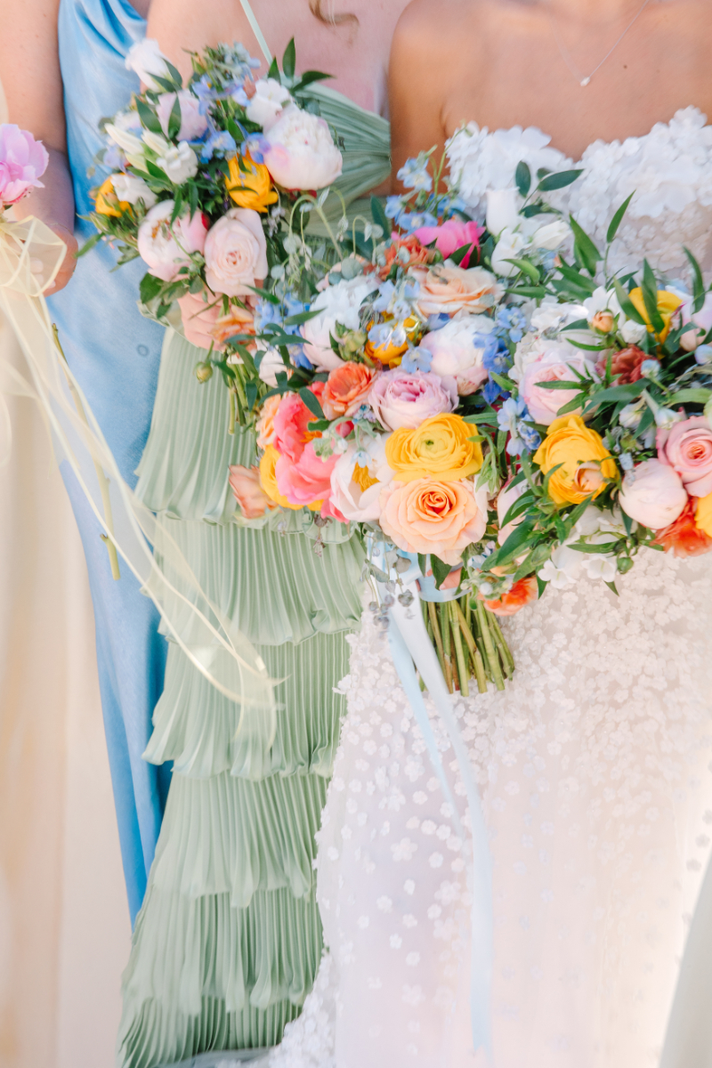 Bride and bridesmaids hold bouquets arranged by one of the best Albuquerque florists, as they take portraits.