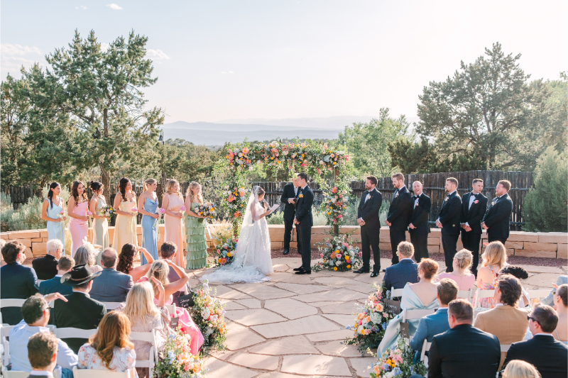 Bride and groom exchange vows surrounded by beautiful florals arranged by one of the best Albuquerque florists.