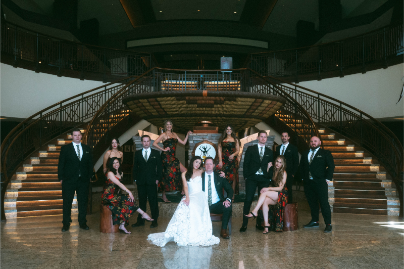 Bridal party poses in front of grand staircase at Inn of Mountain Gods.