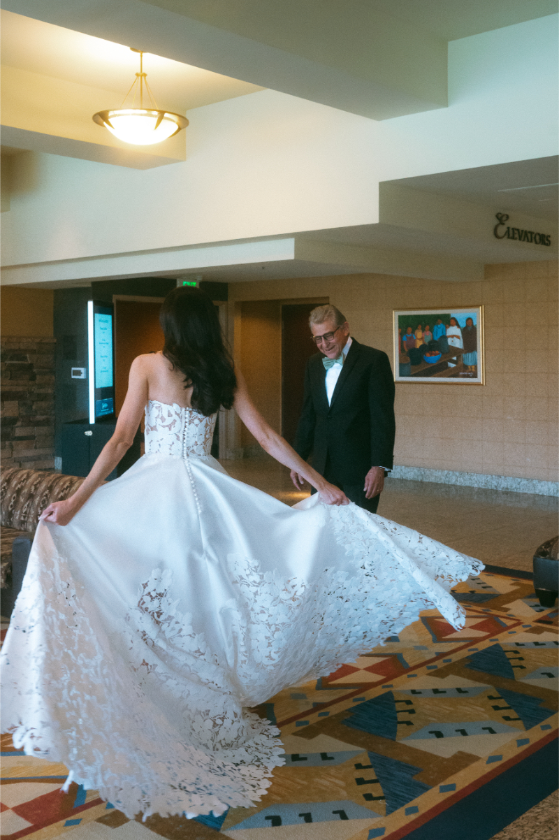 Bride twirls in her dress during first look with her father.