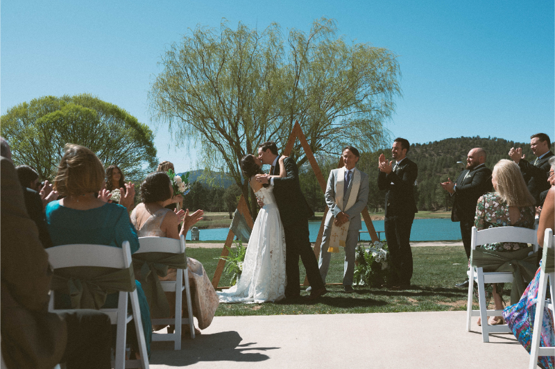 Bride and groom share first kiss during their wedding at Inn of Mountain Gods.