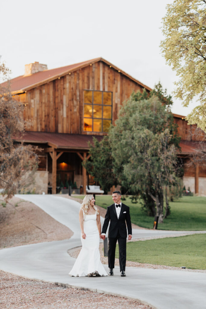 Couple walk together outside of Bishop's Lodge, one of the best places to get married in New Mexico. 