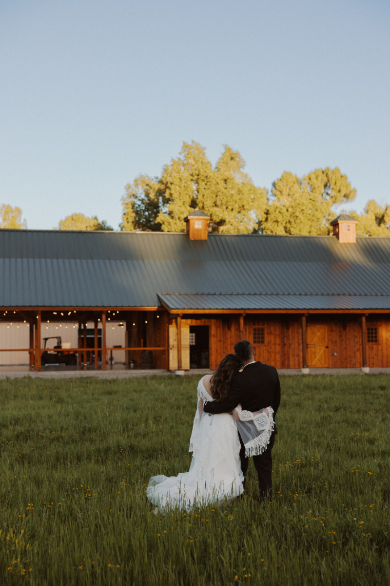 Bride and groom hug as they look at their wedding venue together.
