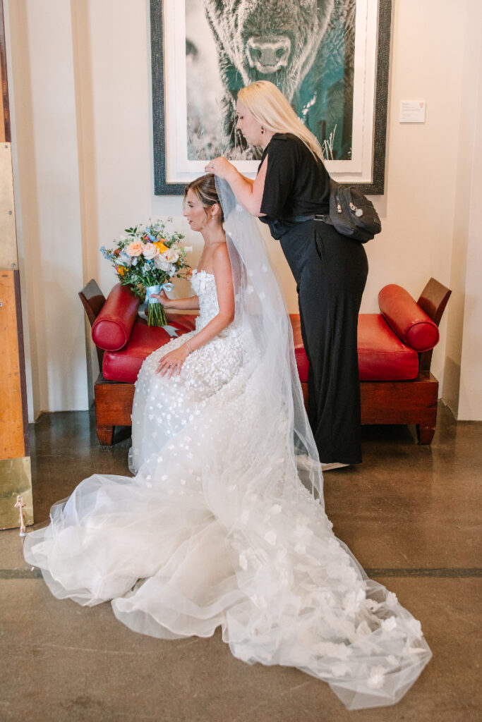 Taylor Fail, owner and lead planner of Verdeaux & Co., helps bride secure her veil, one of the many tasks of a Nashville wedding planner.