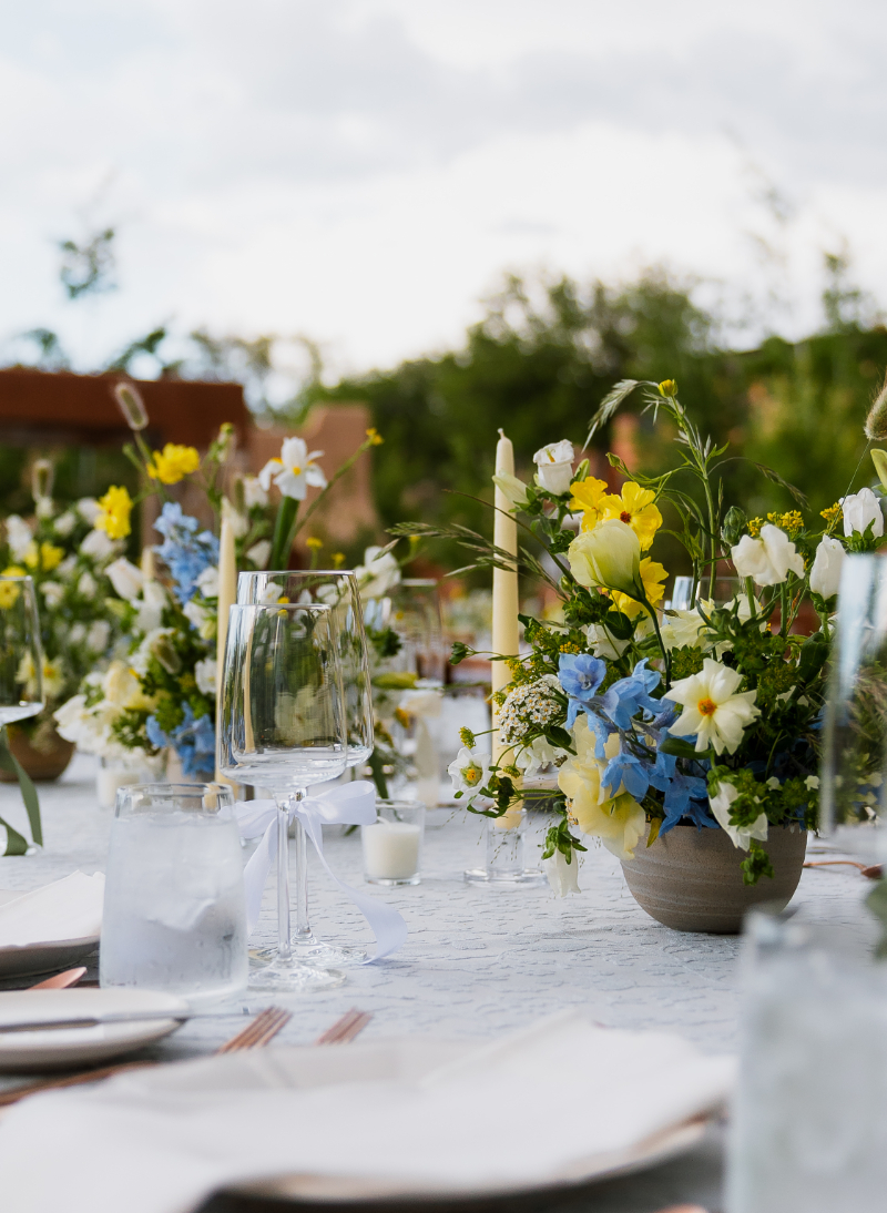 Low floral centerpiece on reception table for garden wedding at Bishop's Lodge in Santa Fe.