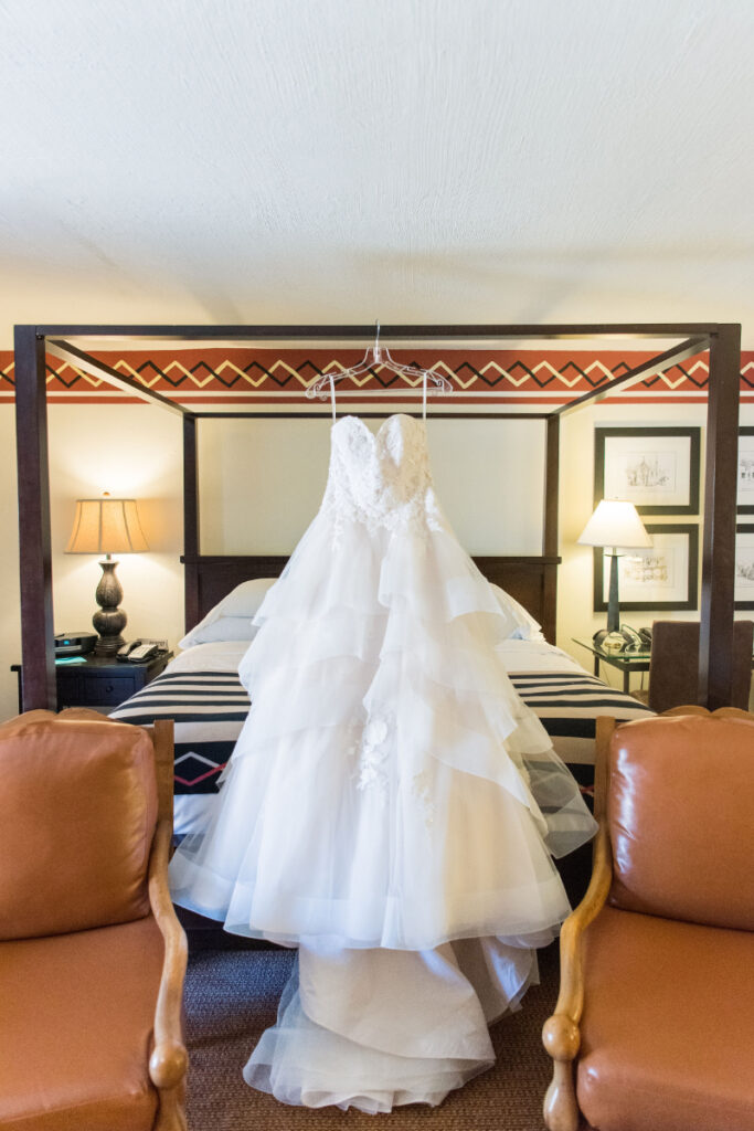 Wedding dress hanging from bed frame at the Inn and Spa of Loretto.