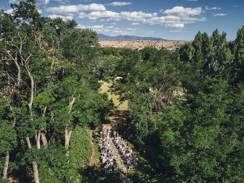 Aerial view of backyard wedding ceremony surrounded by forest.