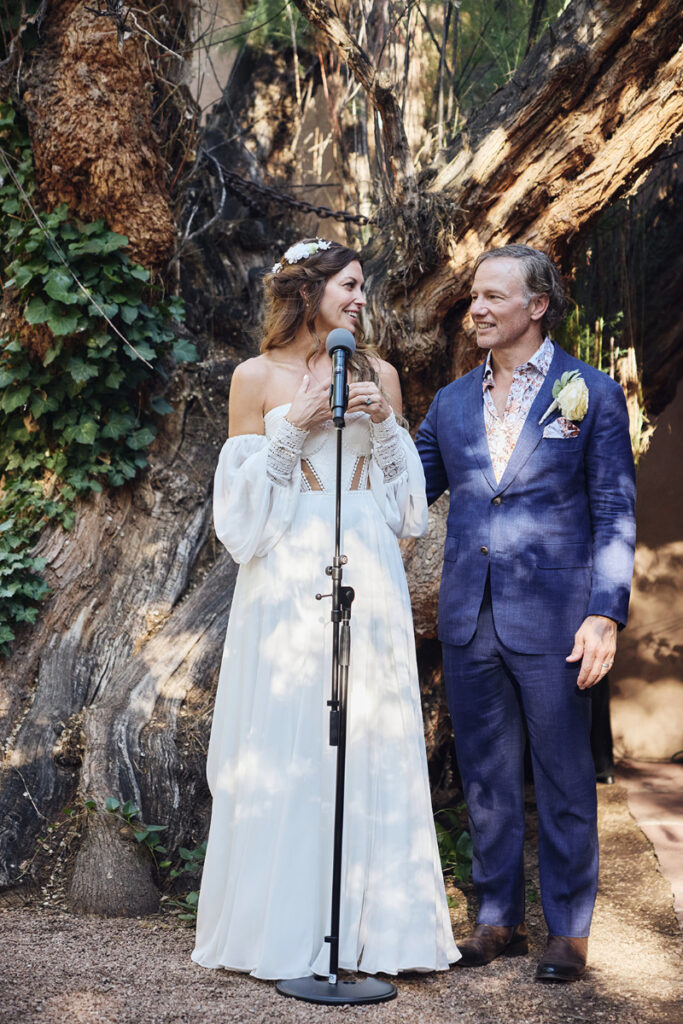 Bride and groom stand together to give speech at their backyard wedding reception.