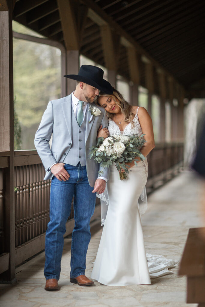 Bride rests head on shoulder of groom as they take wedding portraits after their first look.