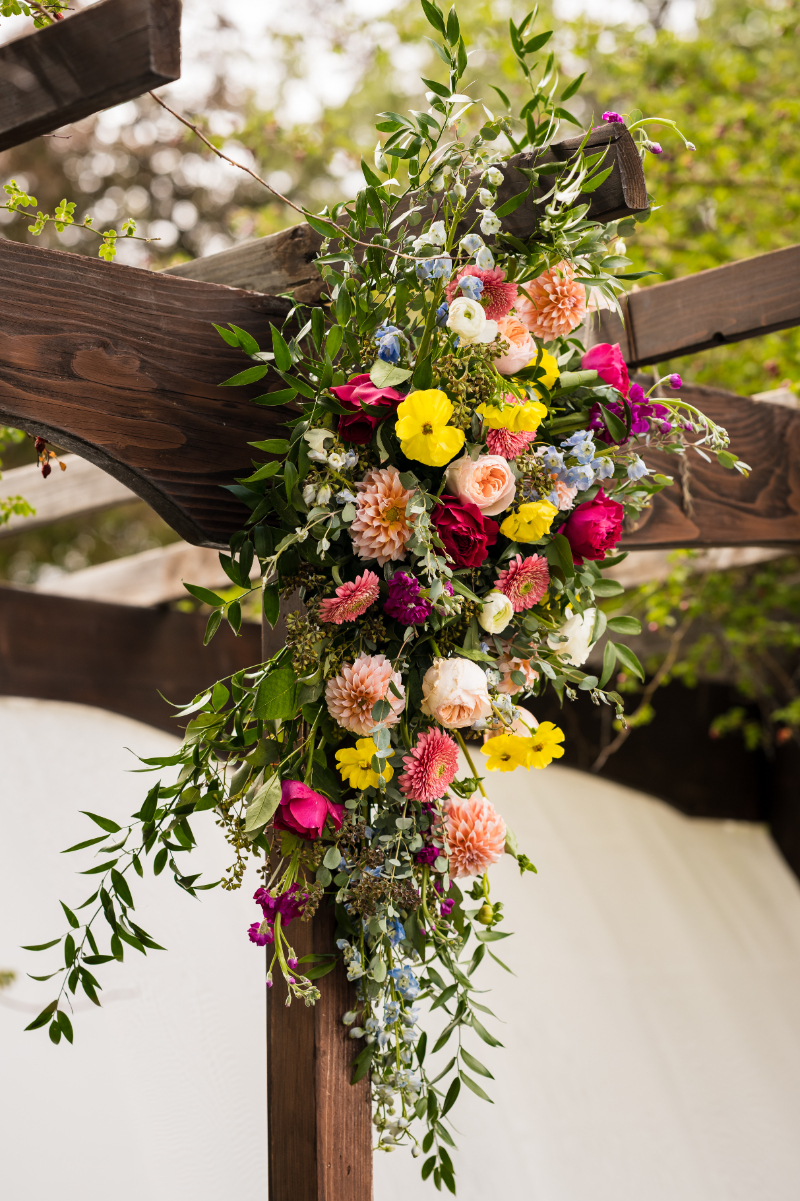 Colorful floral arrangement for ceremony arch.