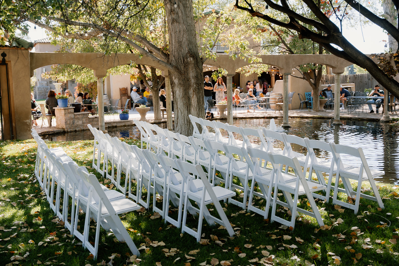 White folding chairs set up for ceremony on mansion lawn.