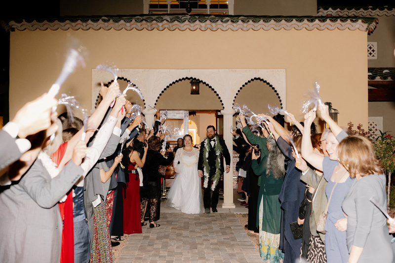 Bride and groom make grand exit from their mansion wedding venues to their guests showering them with celebration.