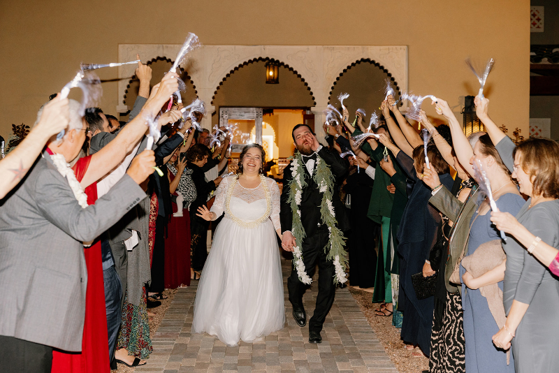 Bride and groom make grand exit from their mansion wedding venues to their guests showering them with celebration.