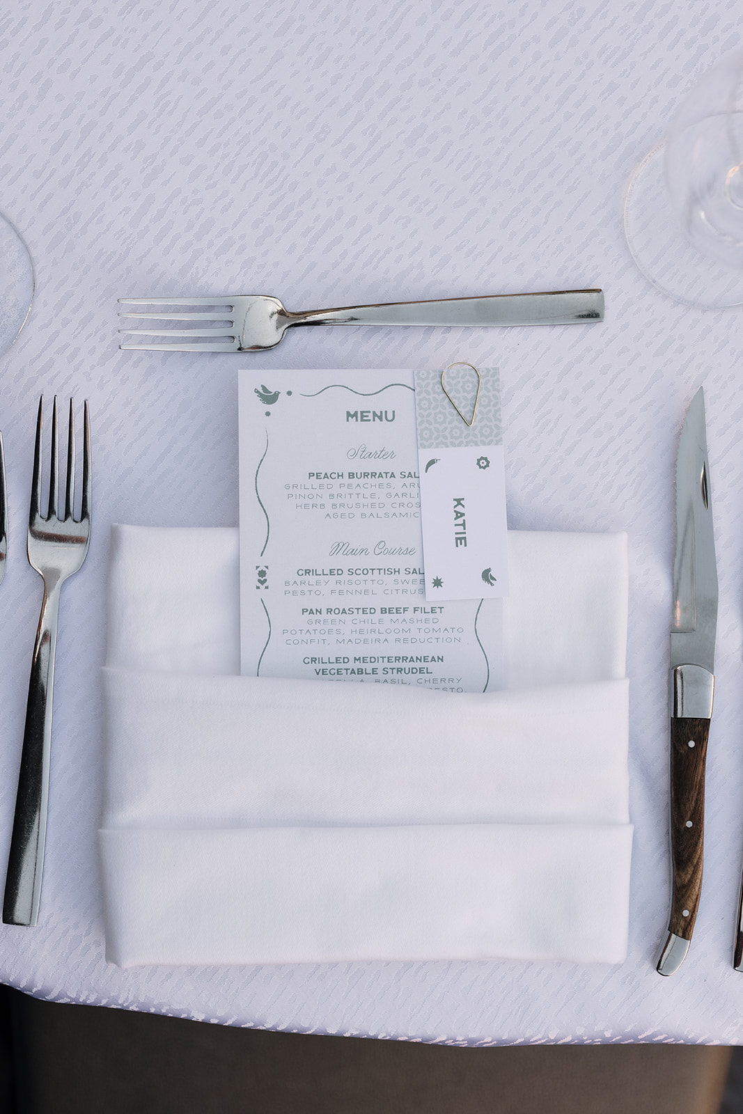 Folded napkin with menu sitting at reception place setting.