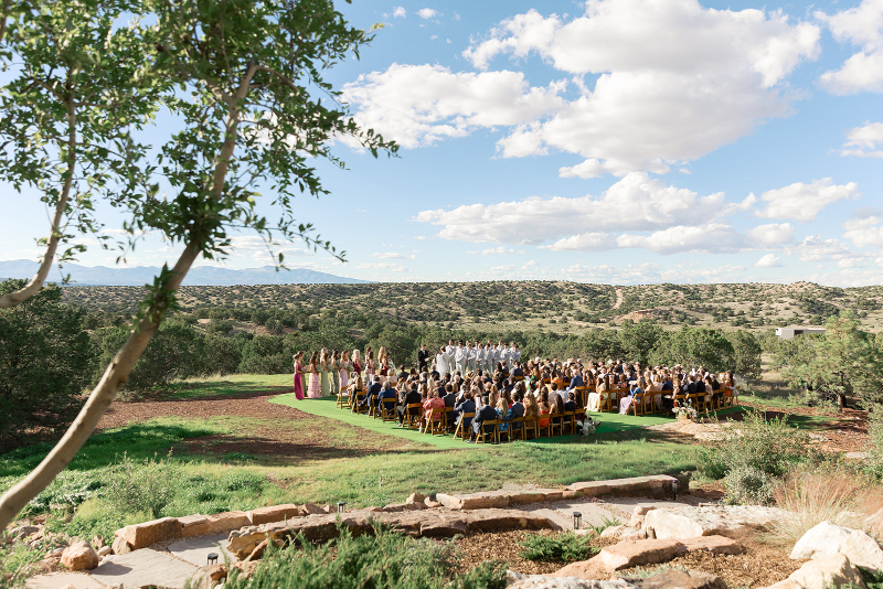 Guests seated in wooden folding chairs waiting for wedding ceremony to start.
