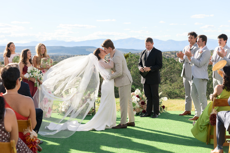 Bride and groom share first kiss at the altar.