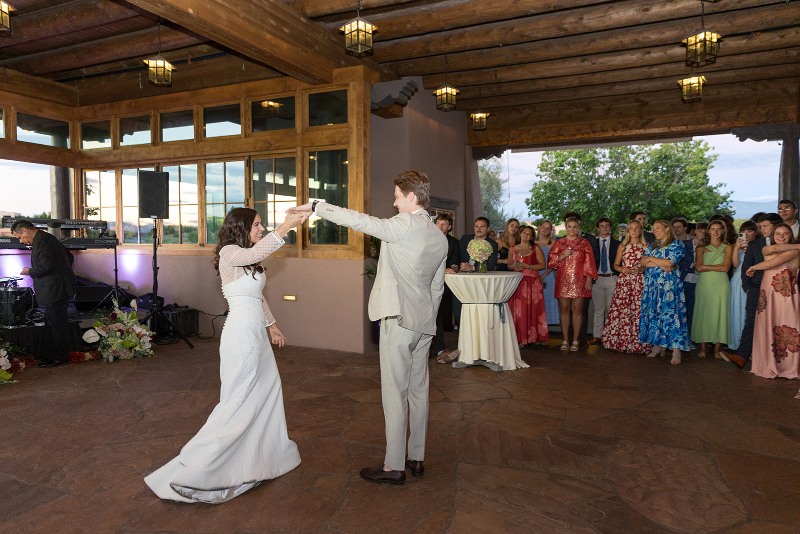 Bride and groom share first dance as married couple, surrounded by their friends and family at their Santa Fe weddings.