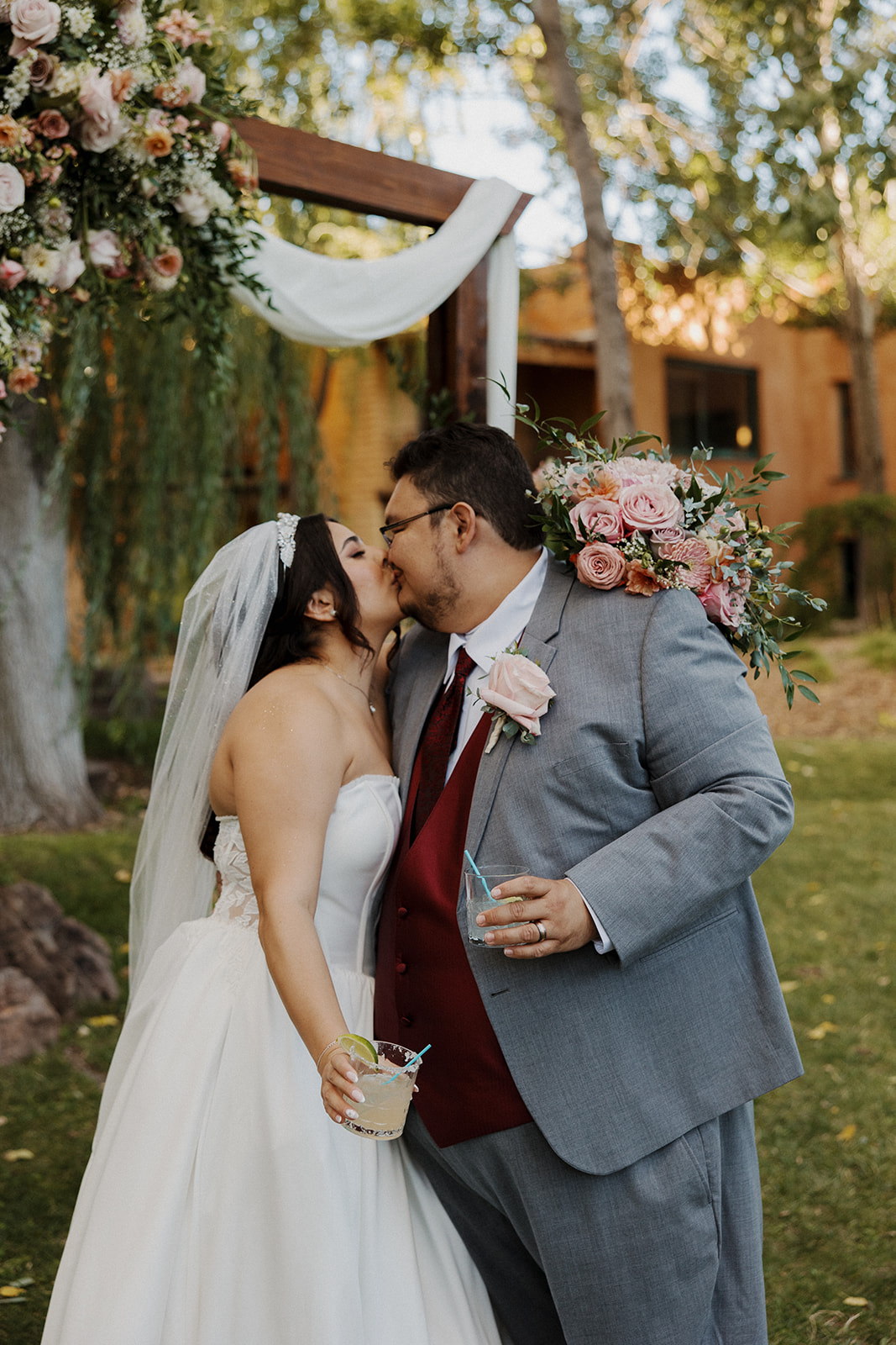Bride and groom share kiss at the altar as they hold their signature drinks for their Tennessee mountain wedding.