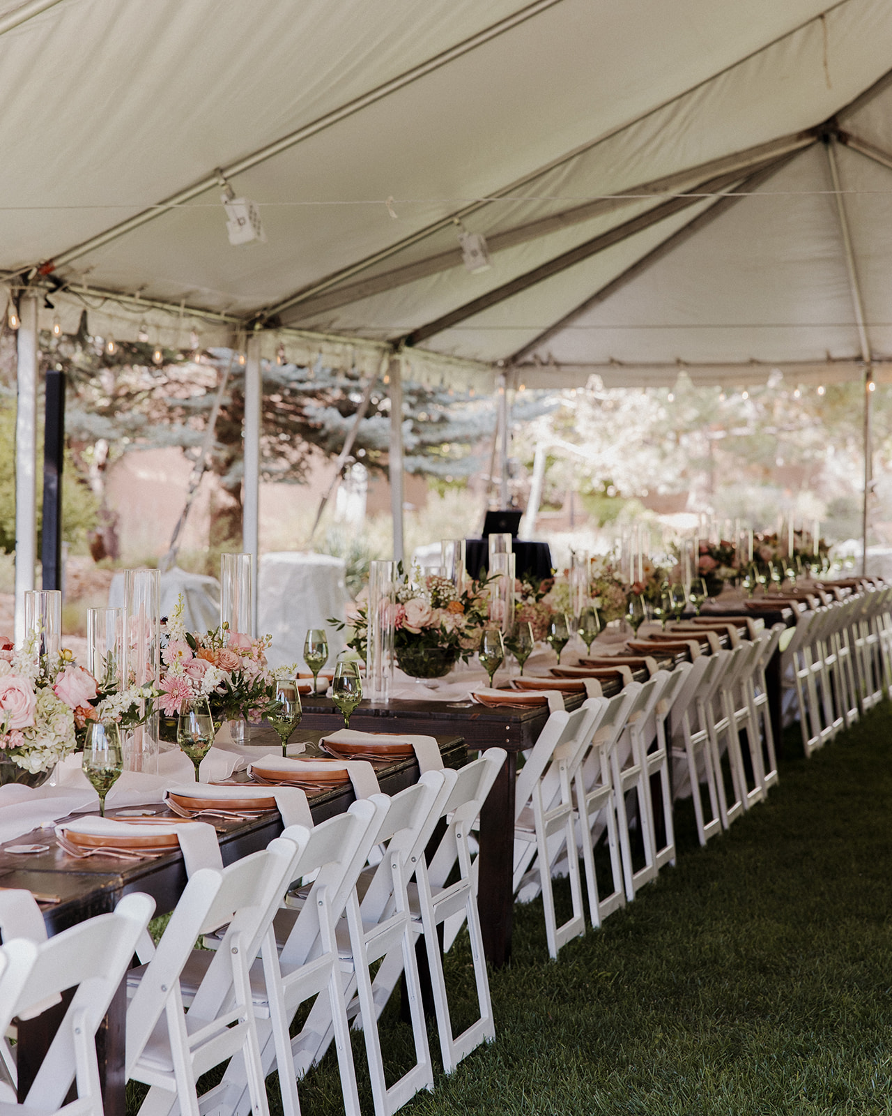 Tented reception decorated with long white tables, folding white tables, and shades of green and pink decor details for a Tennessee mountain wedding.
