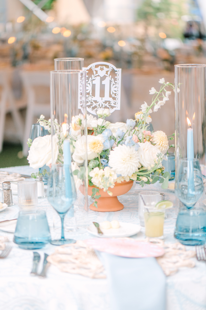 Wedding tablescape with table number 11 sticking outside of floral centerpiece.