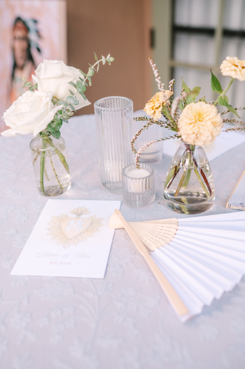 Bud vases and wedding stationery sitting on top of cocktail table.