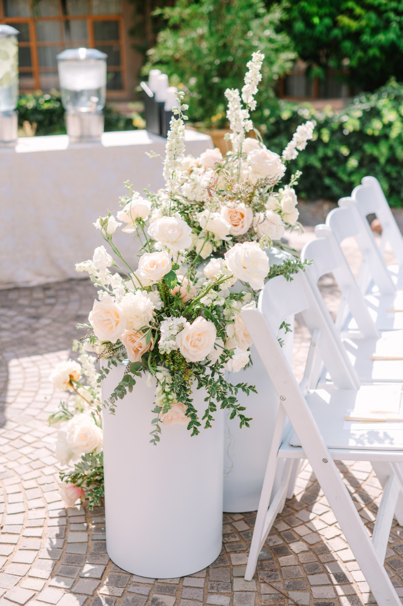 Floral arrangements at end of ceremony aisle sitting on pedestals. The florals perfectly complimenting the bridal bouquet ideas for the day.