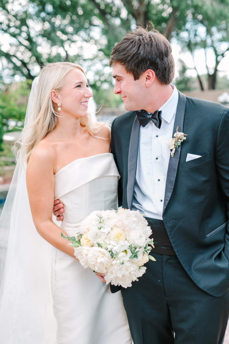 Bride and groom pose for portraits with bride holding her bouquet, a perfect example of bridal bouquet ideas brought to life.