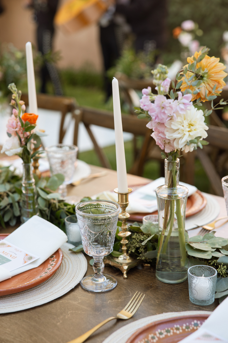 Spring centerpiece ideas for New Mexico wedding using greenery, pillar candles, and bud vases with minimal florals.