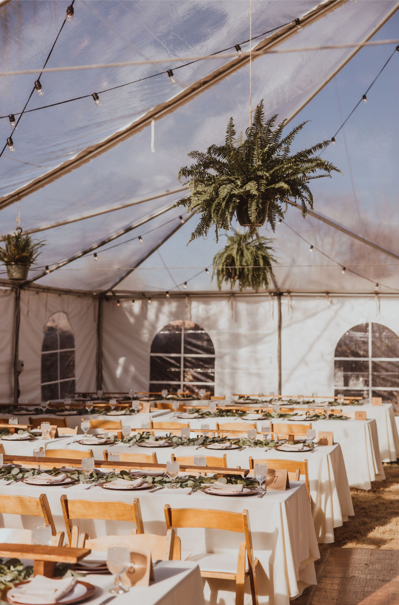 Tented wedding reception decorated with long tables.