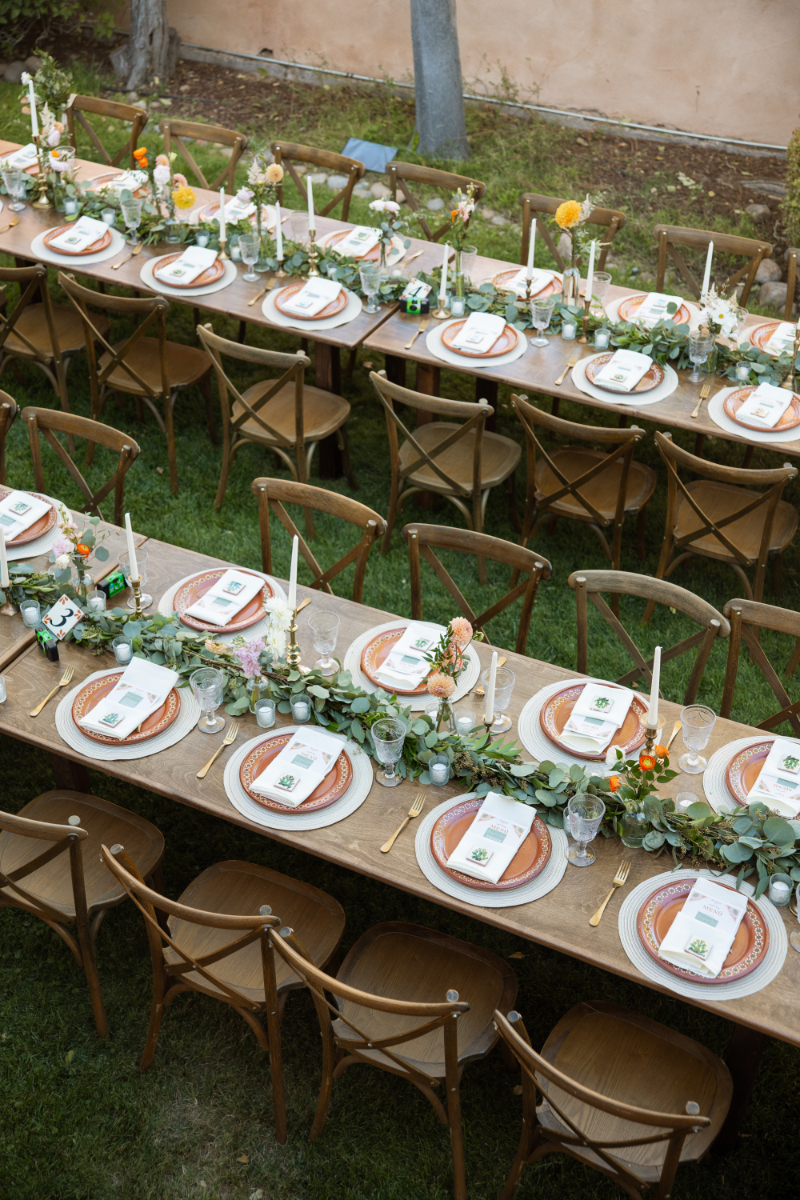 Long wooden tablescape decorated with spring centerpiece ideas for New Mexico wedding.