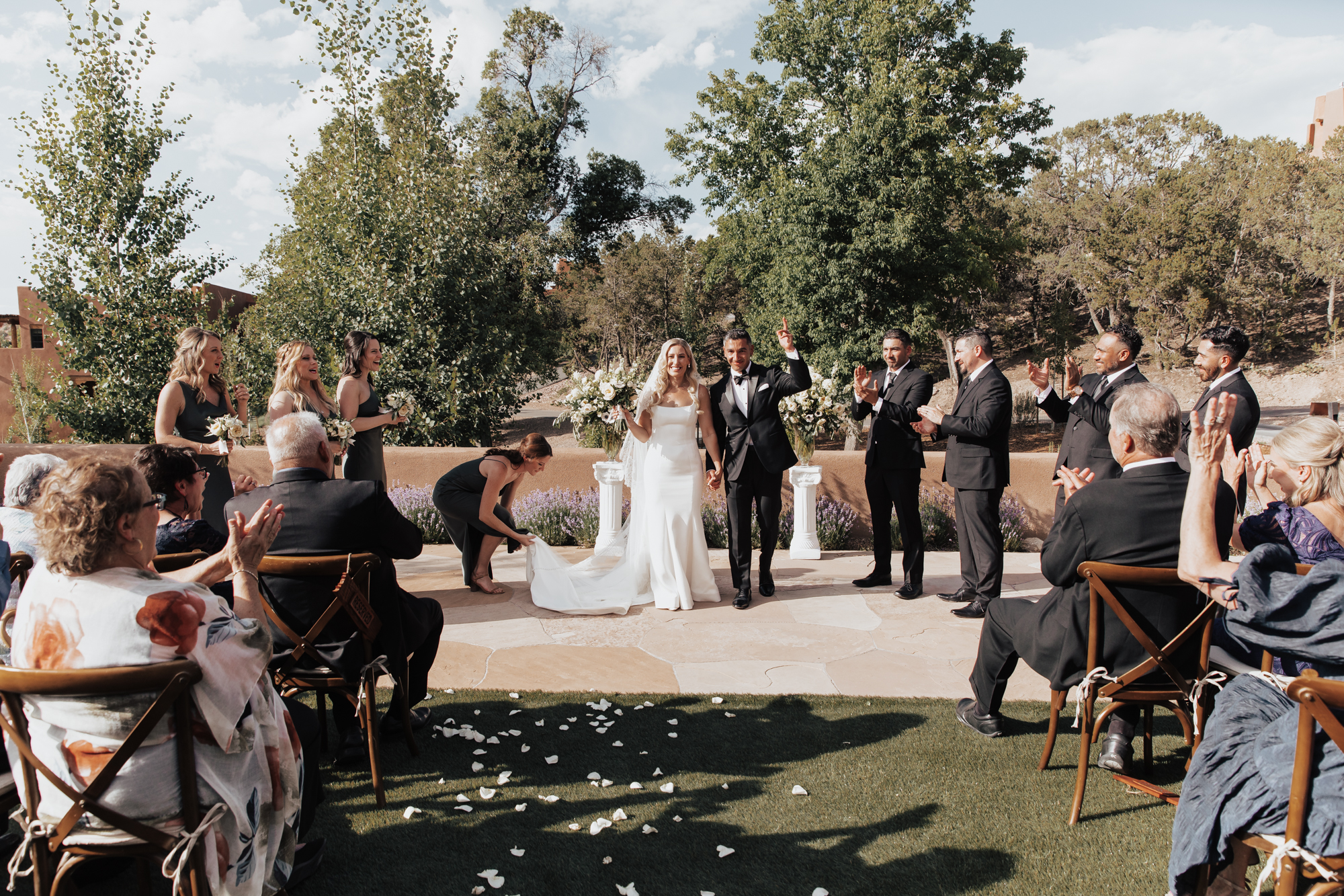 Bride and groom throw their hands in the air as they are celebrated by their friends and family after exchanging vows at their wedding in Tennessee.