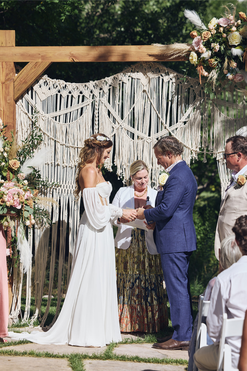 Bride places ring on groom fingers during their Tennessee Highlands wedding ceremony.