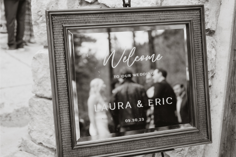 Black and white photo of a mirror etched as a wedding welcome sign.