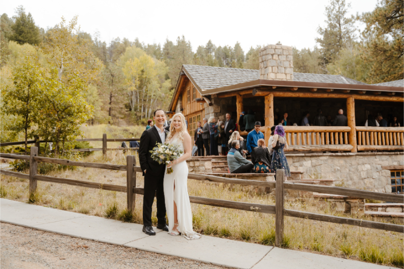 Bride and groom stand together for a photo with their outdoor wedding venues in New Mexico behind them.