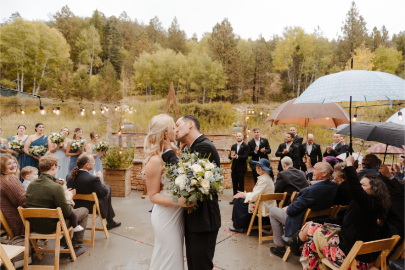 Bride and groom stop mid-aisle to share a kiss after exchanging vows at their outdoor wedding venues in New Mexico.