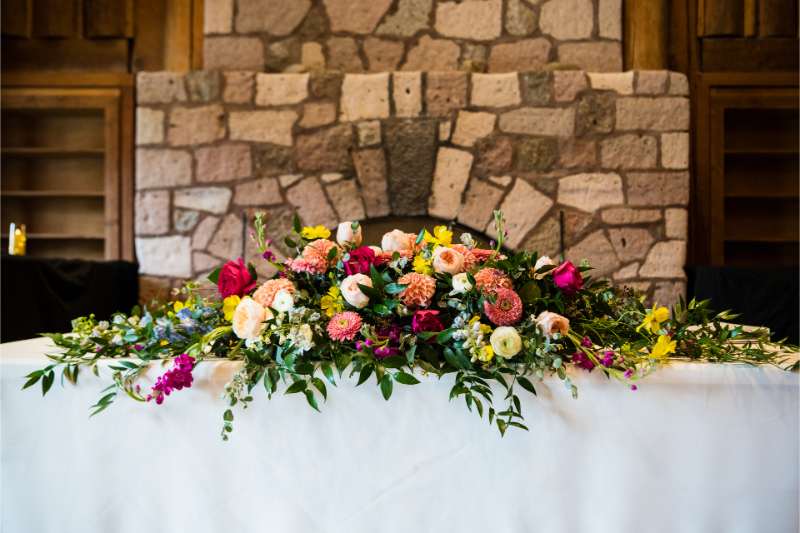 Large wildflower centerpiece for sweetheart table at New Mexico wedding reception.