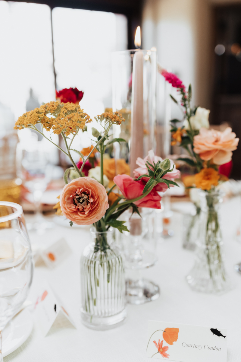 Wildflower centerpiece consisting of colorful florals in a glass bud vase.