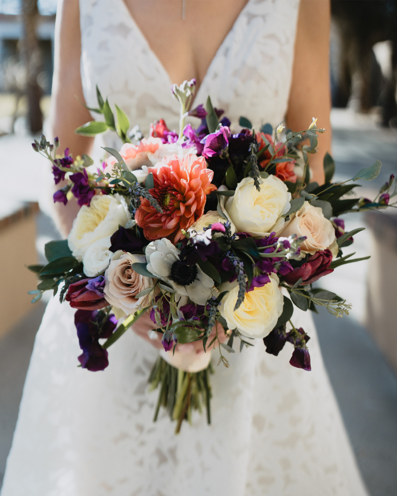 Bride holding colorful bouquet for her desert botanical garden wedding in New Mexico.