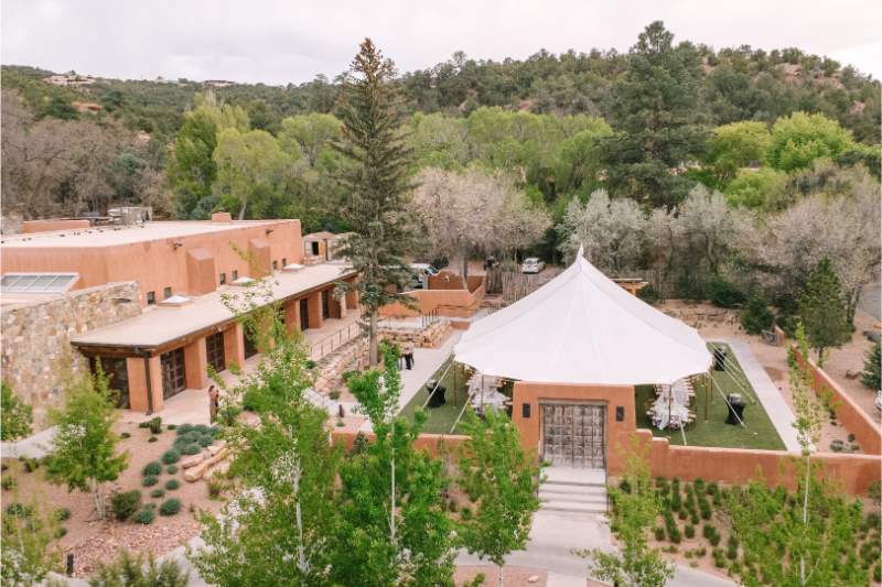 Aerial view of Tennessee wedding venues showing a sailcloth tent reception space surrounded by adobe walls and lush desert landscape.