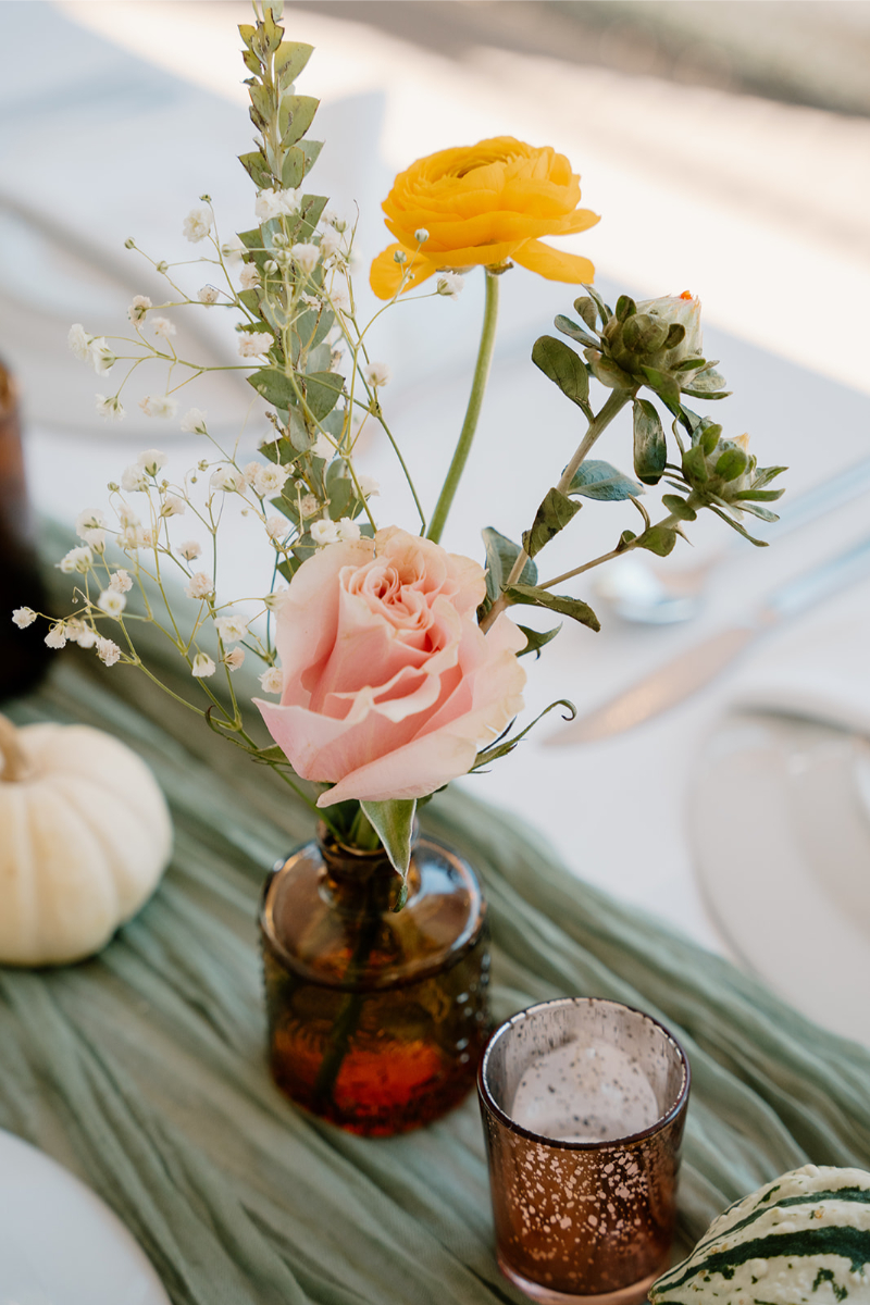 Amber bud vase with fall floral arrangement for a New Mexico celebration.